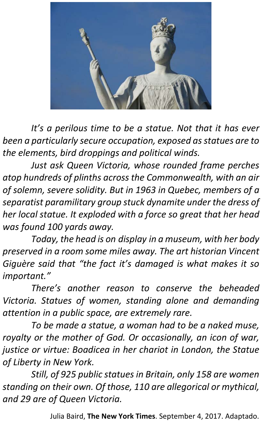 Fotografia de uma estátua da rainha Victoria, vista de baixo contra um céu azul. A estátua usa coroa e vestes longas e segura um cetro em uma das mãos.