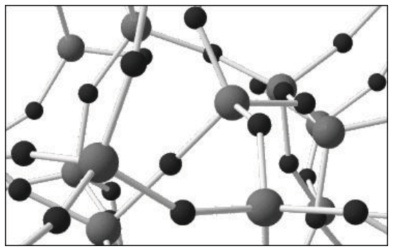 Modelo tridimensional da estrutura microscópica de uma substância no estado sólido, composto por esferas de dois tamanhos conectadas por bastões em rede tridimensional: esferas maiores coordenadas a quatro esferas menores em geometria tetraédrica, e esferas menores conectadas a duas esferas maiores.