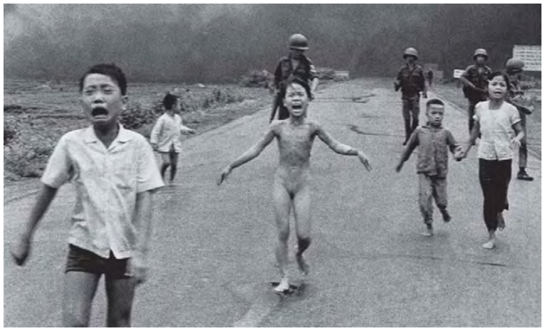 Crianças vietnamitas correm desesperadas por uma estrada durante a Guerra do Vietnã; no centro, a menina Kim Phuc corre nua com os braços abertos, e soldados caminham ao fundo sob densa fumaça.