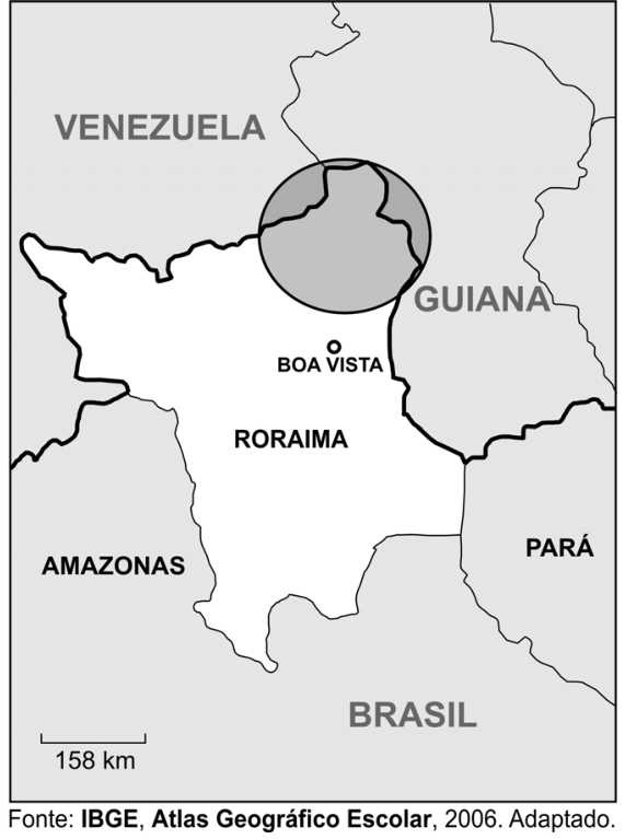 Mapa político do estado de Roraima destacando em cinza, dentro de um círculo preto, uma área ao norte/nordeste do estado que faz fronteira com a Venezuela e com a Guiana. Ao sul, aparecem Amazonas e Pará, além da capital Boa Vista e uma escala gráfica de 158 km.