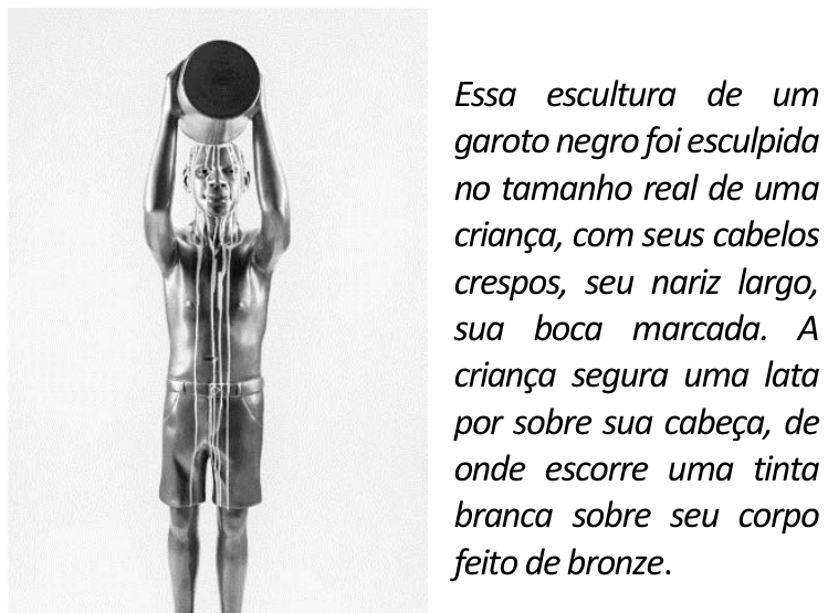 Fotografia de uma escultura de um garoto negro de bermuda, com os braços erguidos, segurando uma lata sobre a cabeça. Tinta branca escorre da lata pela cabeça e pelo corpo. À direita, lê-se: “Essa escultura de um garoto negro foi esculpida no tamanho real de uma criança, com seus cabelos crespos, seu nariz largo, sua boca marcada. A criança segura uma lata por sobre sua cabeça, de onde escorre uma tinta branca sobre seu corpo feito de bronze.”