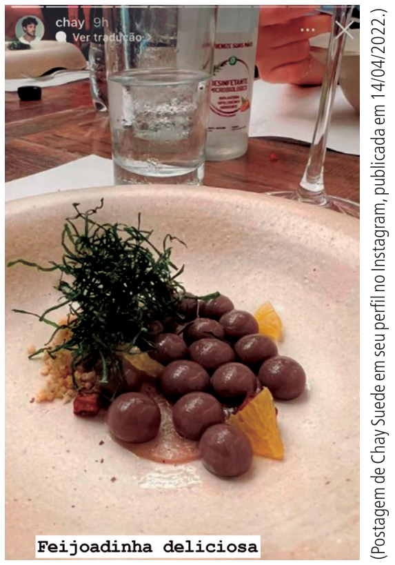 F1 Fotografia de um prato servido em restaurante com esferas marrons gelatinosas imitando feijão, acompanhadas de couve desidratada finamente cortada, farofa e fatias de laranja, com a legenda sobreposta em caixa de texto branca: "Feijoadinha deliciosa". Ao lado, a indicação: "(Postagem de Chay Suede em seu perfil no Instagram, publicada em 14/04/2022.)"