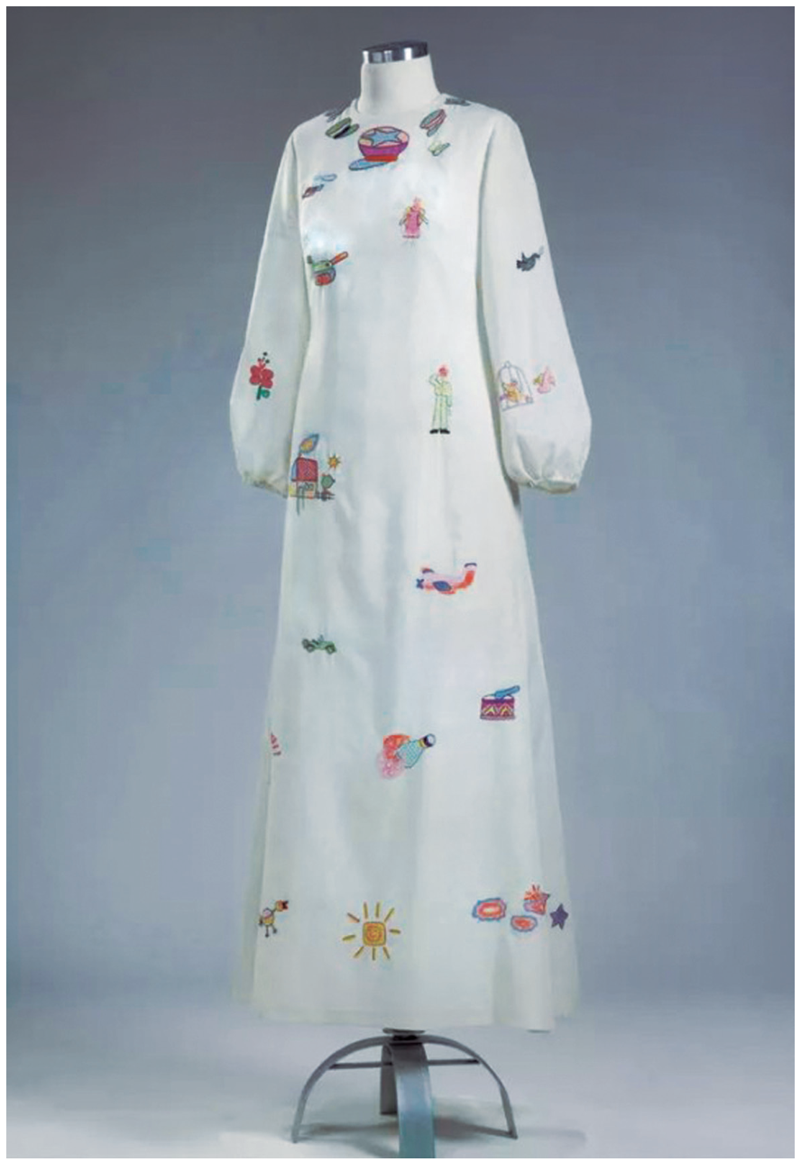 F1 Vestido de noiva longo, branco, com mangas compridas e diversos pequenos bordados coloridos espalhados pelo tecido, incluindo desenhos de anjos, pássaros, casas, sol, tanques e armas de guerra.