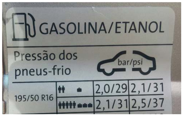 Adesivo informativo de calibração de pneus de um veículo com a inscrição "GASOLINA/ETANOL" e "Pressão dos pneus-frio". Ao lado do desenho esquemático de um carro com o indicador "bar/psi", uma tabela mostra, para a medida 195/50 R16: com carga baixa (dois passageiros e uma mala), 2,0/29 bar/psi nos pneus dianteiros e 2,1/31 bar/psi nos pneus traseiros; com lotação máxima (cinco passageiros e três malas), 2,1/31 bar/psi nos pneus dianteiros e 2,5/37 bar/psi nos pneus traseiros.