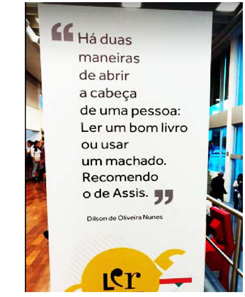 Totem com a frase: "Há duas maneiras de abrir a cabeça de uma pessoa: Ler um bom livro ou usar um machado. Recomendo o de Assis.", assinada por Dilson de Oliveira Nunes. Abaixo, há um logotipo circular com a palavra "ler".
