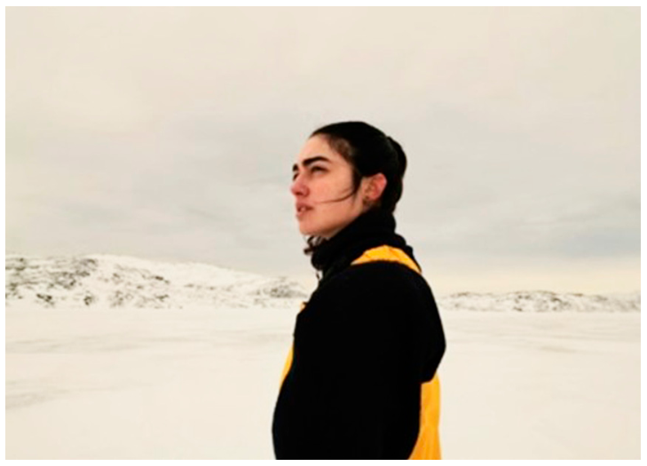 Fotografia de Tamara Klink em primeiro plano de perfil, em meio a uma paisagem ártica coberta por neve.
