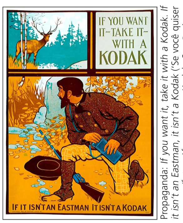 F1 Propaganda da Kodak dividida em seções. No quadro superior esquerdo, um cervo em meio à vegetação e árvores; no quadro superior direito, o texto “IF YOU WANT IT–TAKE IT–WITH A KODAK”. Na parte inferior, um homem barbudo com trajes de caça ajoelhado em terreno rochoso com folhagens, segurando uma câmera fotográfica; no chão à sua frente repousam uma espingarda e um chapéu. Na base, lê-se: “IF IT ISN’T AN EASTMAN IT ISN’T A KODAK”.