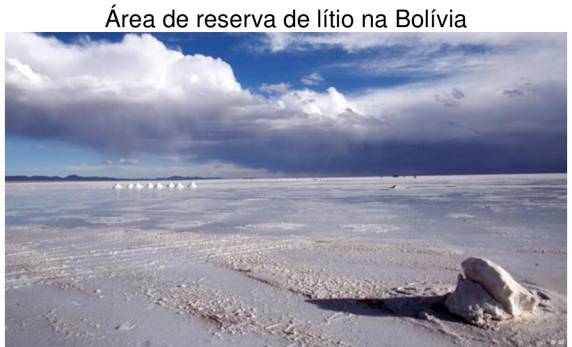 Fotografia de um salar na Bolívia, com uma vasta planície branca salina estendendo-se até o horizonte sob céu nublado, com o título: Área de reserva de lítio na Bolívia.