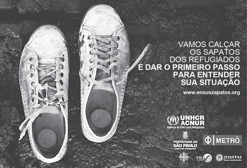 Cartaz de campanha mostrando um par de tênis brancos desgastados e enlameados sobre um chão úmido e escuro. À direita, lê-se o texto da campanha: "VAMOS CALÇAR OS SAPATOS DOS REFUGIADOS E DAR O PRIMEIRO PASSO PARA ENTENDER SUA SITUAÇÃO", seguido do endereço eletrônico www.ensuszapatos.org e dos logotipos do ACNUR (Agência da ONU para Refugiados), da Prefeitura de São Paulo - Direitos Humanos, do Metrô e de outras instituições apoiadoras.
