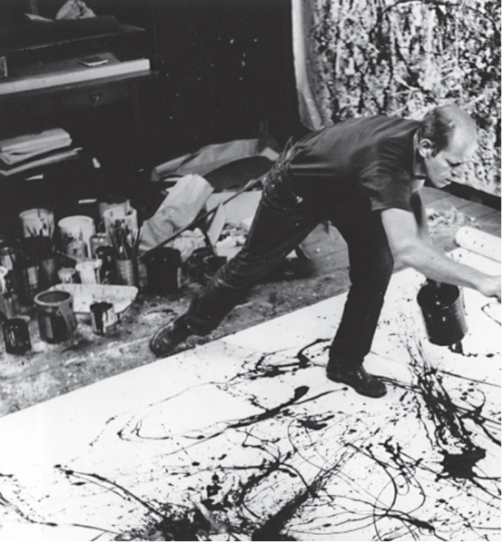 Fotografia em preto e branco de Jackson Pollock curvado sobre uma tela no chão em seu ateliê, aplicando tinta diretamente de uma lata. Ao fundo, latas de tinta e pincéis.