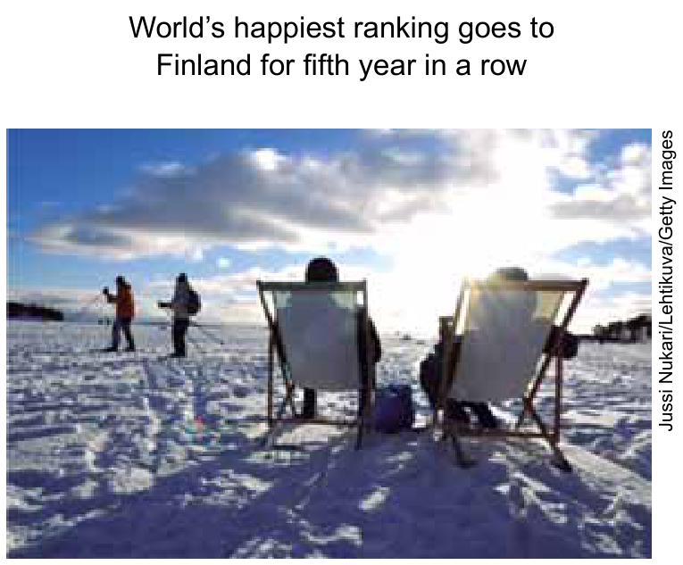 Título: "World's happiest ranking goes to Finland for fifth year in a row". Fotografia de duas pessoas de costas sentadas em espreguiçadeiras sobre uma paisagem de neve ensolarada, com esquiadores ao fundo à beira-mar de Helsinque. Crédito lateral: Jussi Nukari/Lehtikuva/Getty Images.