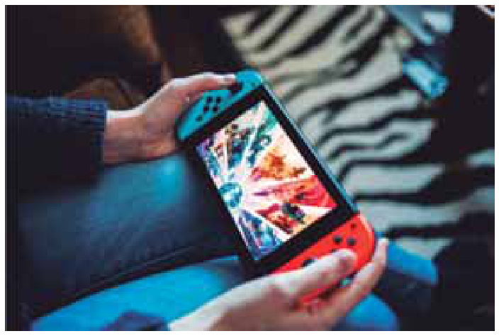 Pessoa segurando com as mãos um videogame portátil enquanto joga