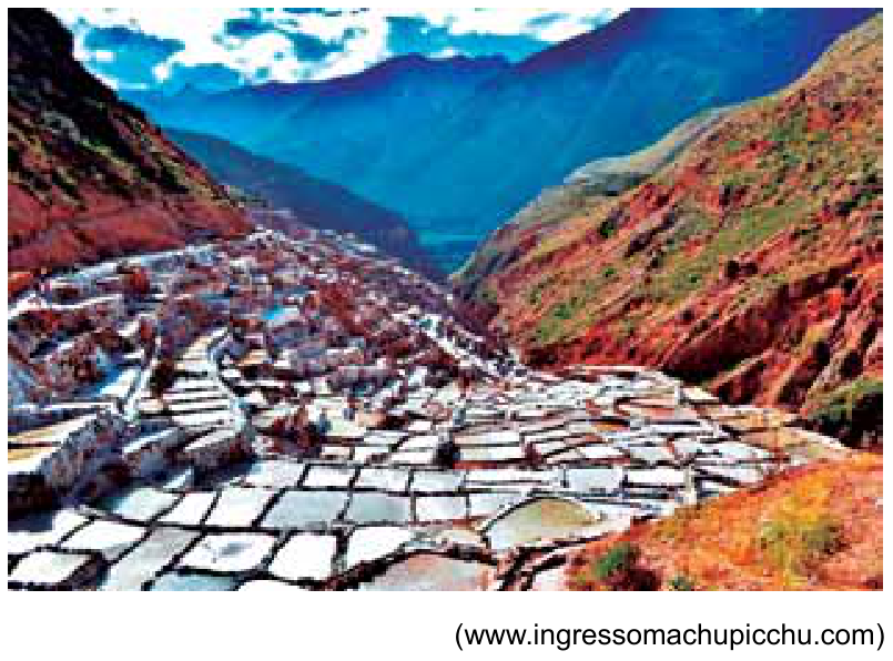F1 Fotografia das Salinas de Maras em um vale entre montanhas, mostrando centenas de piscinas rasas retangulares em degraus para evaporação de água salgada.