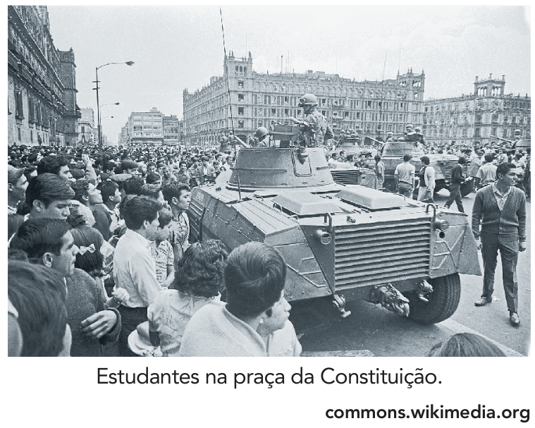 Multidão de estudantes e populares ao redor de veículos blindados do exército na praça da Constituição.