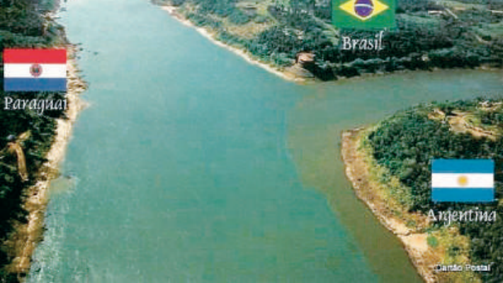 Confluência de rios demarcando a Tríplice Fronteira entre Brasil, Paraguai e Argentina, com as respectivas bandeiras sobre cada território