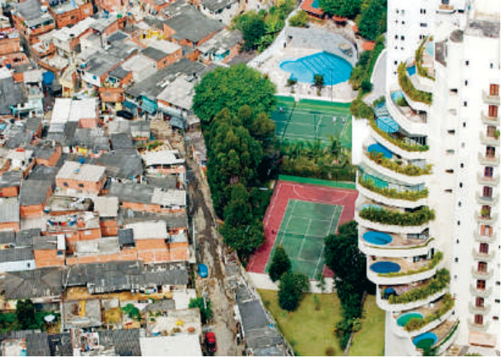 Fotografia aérea mostrando a extrema desigualdade socioeconômica na divisa entre a favela de Paraisópolis e um condomínio de luxo com piscinas nas varandas no Morumbi, em São Paulo