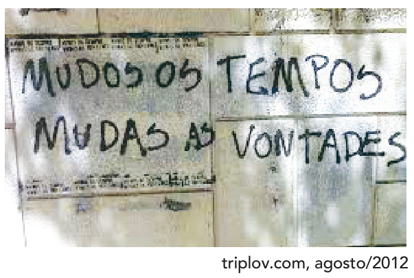 Fotografia de um muro em Portugal com o grafite “MUDOS OS TEMPOS / MUDAS AS VONTADES”, escrito em duas linhas. No canto inferior direito, o crédito: “triplov.com, agosto/2012”.