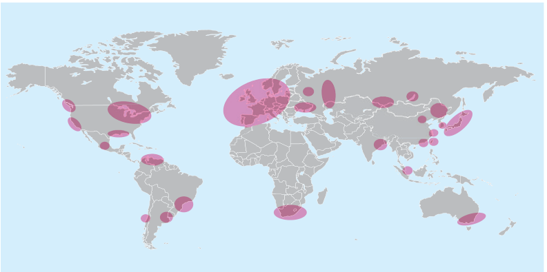 Mapa-múndi com continentes em cinza, oceanos em azul-claro e manchas ovais rosas indicando as principais áreas industriais. A maior mancha abrange parte da Europa; outras aparecem na América do Norte, no México, no norte e no sudeste da América do Sul, no sul da África, na Rússia, na Índia, no leste e sudeste da Ásia e no sudeste da Austrália.