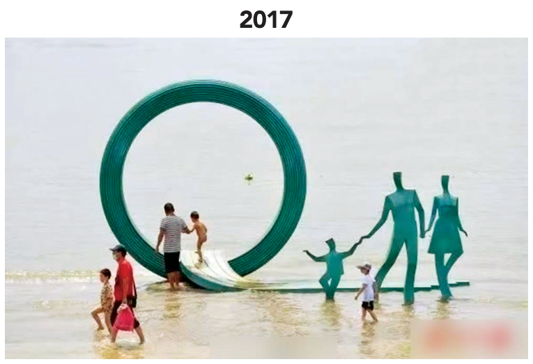 F1 Escultura de 2017 com um casal e um filho ao lado de um grande aro circular