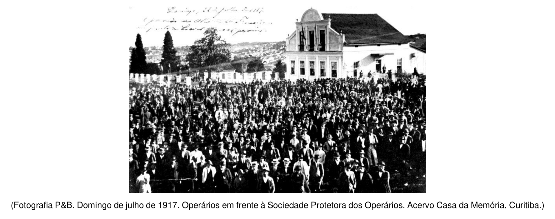 F1 Fotografia em preto e branco de uma grande concentração de operários em frente ao edifício da Sociedade Protetora dos Operários em Curitiba