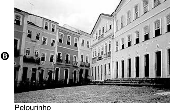 Fotografia de uma praça de calçamento de pedra cercada por edifícios históricos de vários pavimentos. Legenda: Pelourinho.