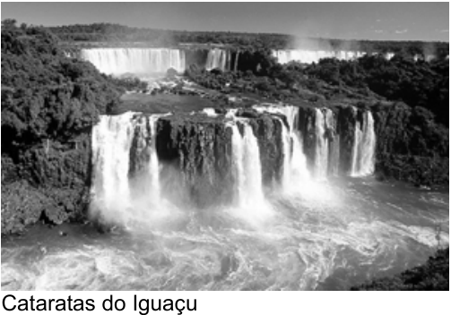 Fotografia de várias quedas-d’água cercadas por vegetação, com águas turbulentas na parte inferior. Legenda: Cataratas do Iguaçu.