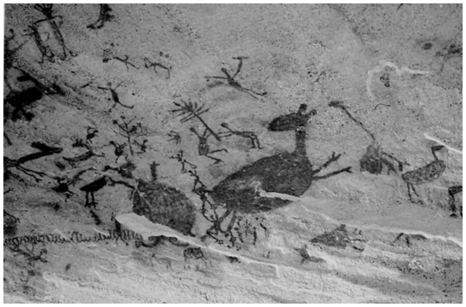 Pintura rupestre mostrando diversas figuras humanas e animais desenhados em tom escuro sobre superfície rochosa.