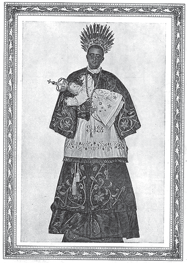 Ilustração em preto e branco com moldura decorada representando São Benedito, um santo negro em vestes clericais ornamentadas com bordados e coroa de raios na cabeça, segurando o Menino Jesus nos braços.