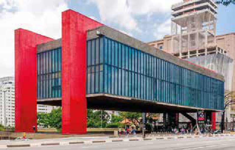 F1 Fotografia do Museu de Arte de São Paulo (MASP), projetado por Lina Bo Bardi, destacando seus grandes pilares vermelhos e o vão livre sobre a Avenida Paulista.
