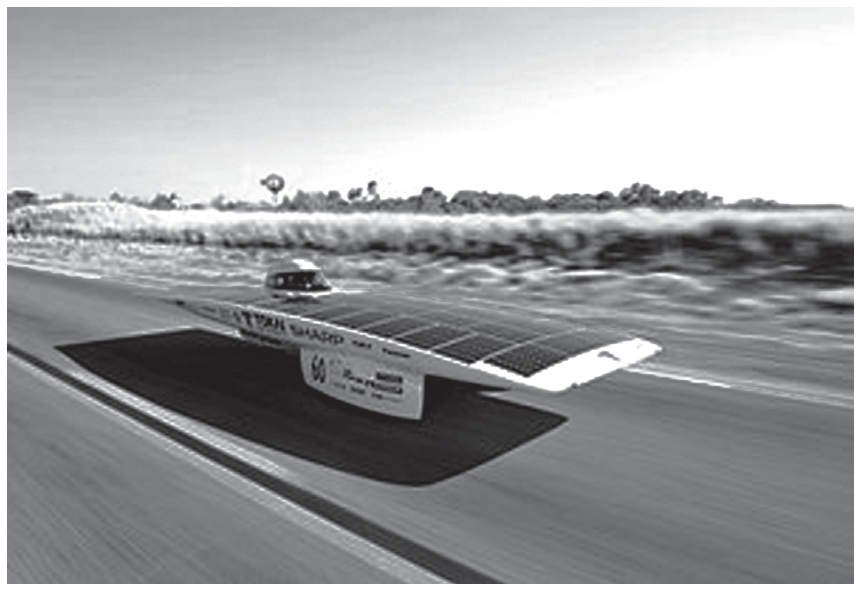 Fotografia do carro solar Tokai Challenger em movimento em uma pista asfaltada, com perfil aerodinâmico e achatado, coberto de células solares fotovoltaicas