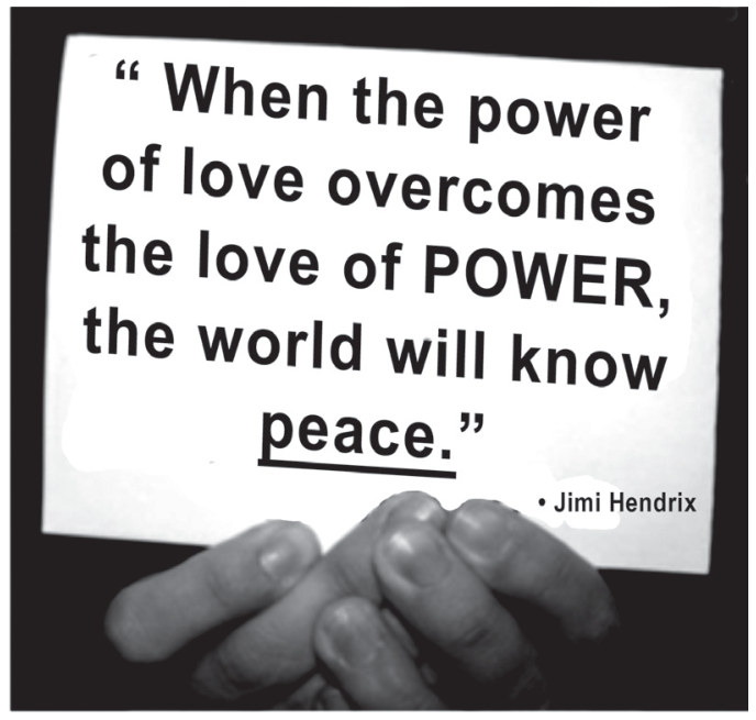 Fotografia em preto e branco mostrando mãos segurando uma placa onde se lê: “When the power of love overcomes the love of POWER, the world will know peace.” seguido pela assinatura “• Jimi Hendrix”. A palavra “peace.” está sublinhada.
