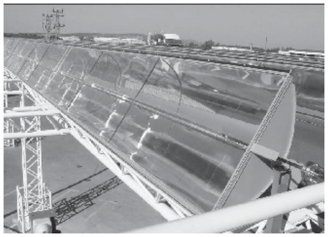 Fotografia em perspectiva de um coletor solar parabólico com espelho côncavo e receptor tubular central