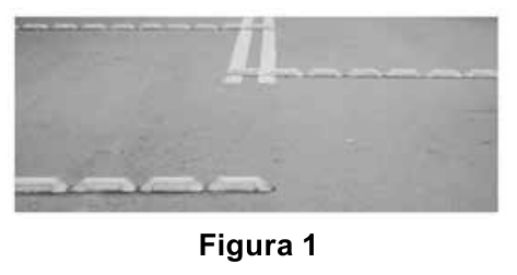 Fotografia em preto e branco de uma pista de trânsito com tachões instalados sobre o asfalto, acompanhada da legenda Figura 1.