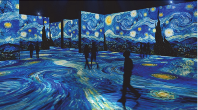 F1 Pessoas caminhando em uma sala escura cujas paredes e chão recebem projeções luminosas em grande escala da pintura A Noite Estrelada, de Vincent van Gogh.