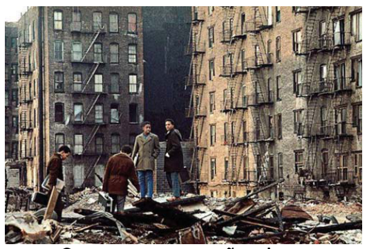 F10 Fotografia de jovens caminhando sobre escombros diante de edifícios antigos no Bronx em Nova York